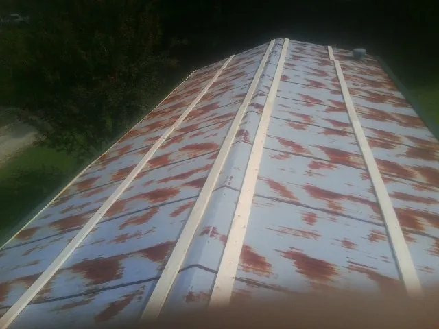 Rusted metal roof panels with new wood purlins before replacement — Storm Damage Roof Repair in Myrtle Point by Roofing Brothers