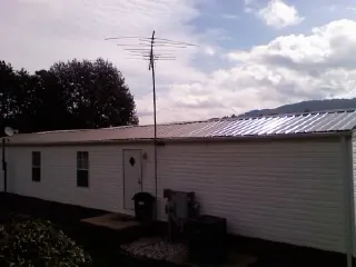 New metal roof on a single wide mobile home with a TV antenna in Myrtle Point