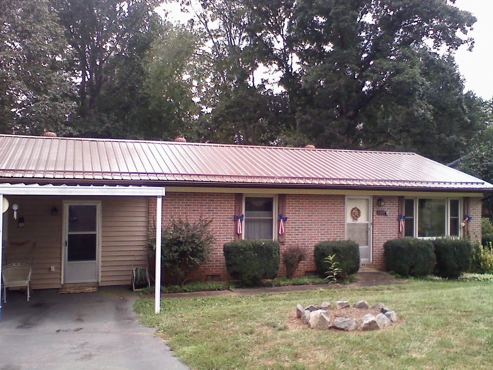 Bronze metal roof and carport on a brick ranch home — Roof Repair work by our crew in Myrtle Point